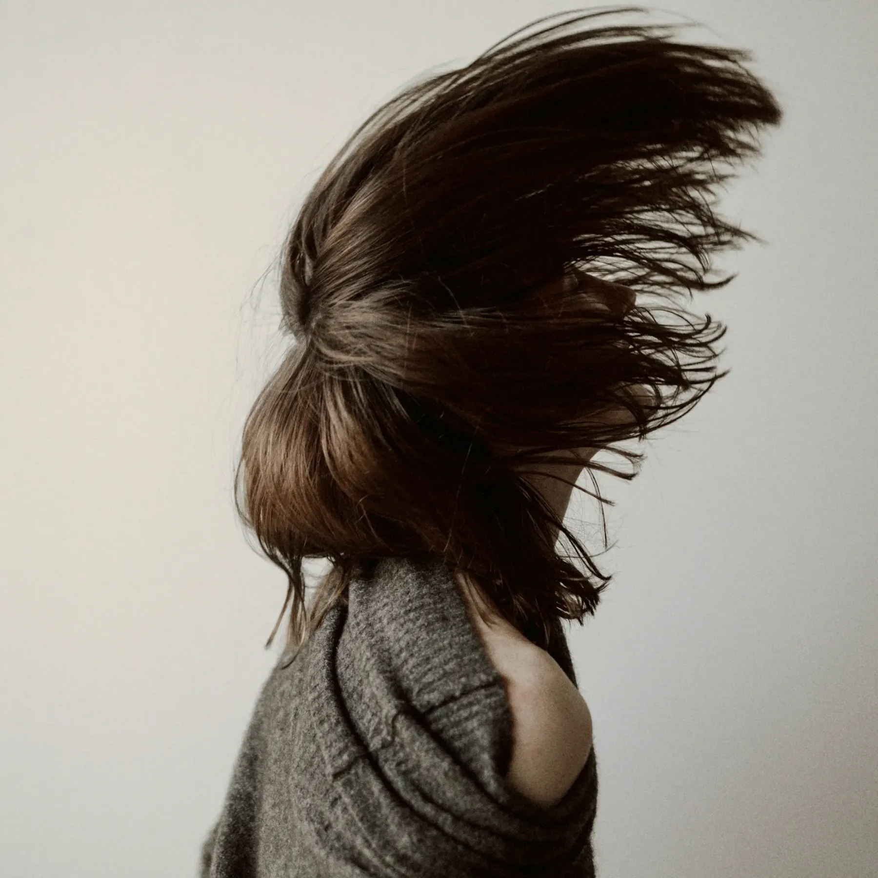 A woman flicking glossy brunette hair
