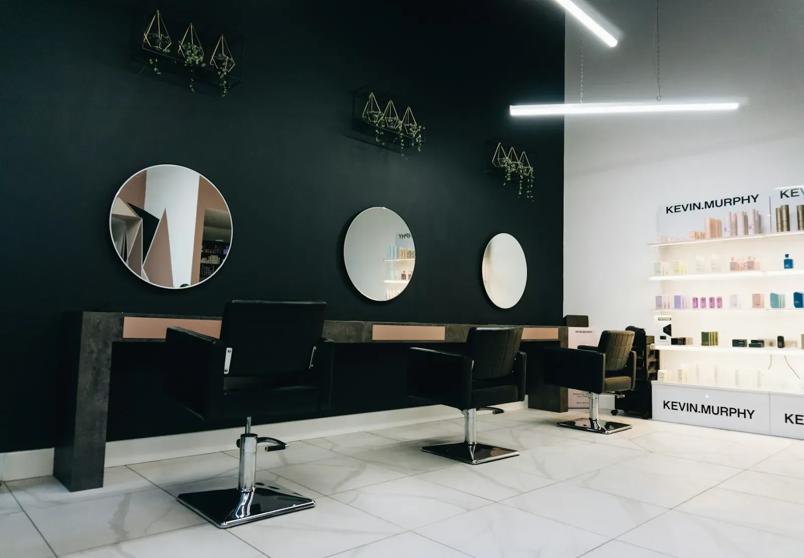 A modern salon with round mirrors and black styling chairs